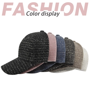Vue détaillée des casquettes en tweed à carreaux montrant les fils métalliques tissés