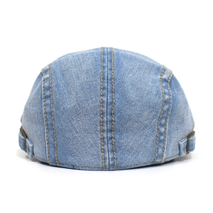 Rear view of light blue washed denim newsboy cap with copper buckles and yellow stitching