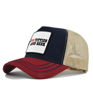 Detail einer rot-blau-beigen Trucker-Mütze mit Netzeinsätzen und gesticktem Aufnäher