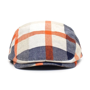 Detailed close-up of orange and navy plaid pattern on classic British style flat cap