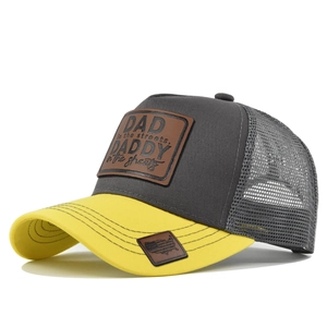 Detail of grey mesh trucker hat with yellow brim and leather DAD patch embroidery