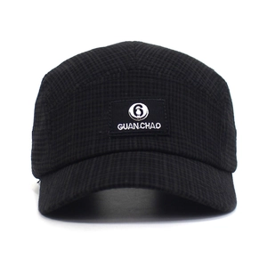 Detail van zwarte katoenen baseballpet met geweven textuur en Guan Chao-letterpatch