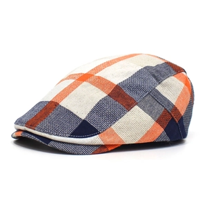 Close-up of orange and navy plaid beret showing the breathable cotton blend texture