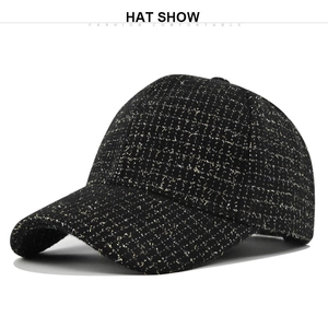 Vue détaillée du tissu en tweed noir de la casquette avec des fils métalliques dorés