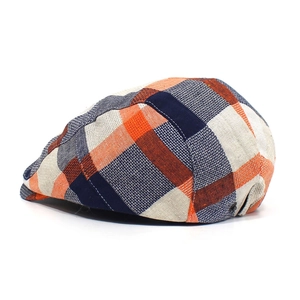 Detail of multi-color plaid flat cap with orange and navy pattern and metal side buckle