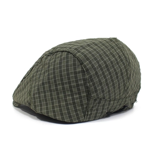Detail view of the stitching and green plaid pattern on this stylish flat cap