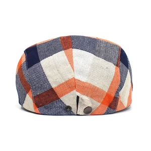 Detail view of the colorful plaid flat cap with adjustable metal snap buttons on the back