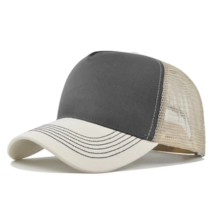 Side view of a two-tone mesh trucker hat with dark gray fabric and cream brim detailing
