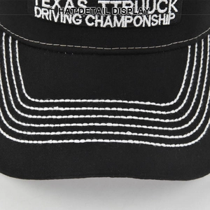Detail shot of black baseball cap showing white contrast stitching and 3D embroidery textures