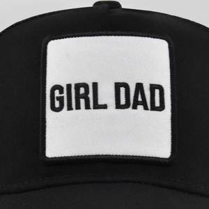 Dettaglio ravvicinato della toppa ricamata GIRL DAD su cappello da baseball nero con rete