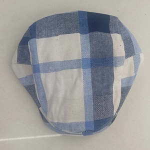 Detailed top view of blue checkered newsboy cap with breathable cotton fabric texture