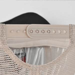 Close-up of beige mesh trucker hat with adjustable plastic snapback fastener