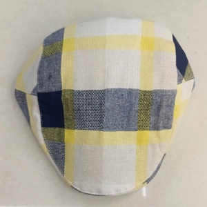 Top view of a colorful plaid flat cap made of textured linen cotton fabric