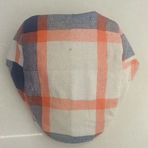 Detailed close-up showing the red and blue plaid texture of a retro casual beret cap
