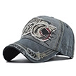 Détail de casquette baseball en jean gris délavé avec broderie requin 3D et bordure usée