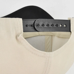 Detail des schwarzen Snapback-Verschlusses an einer cremefarbenen Baumwoll-Basecap