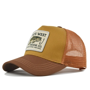 Detail of a mesh trucker hat featuring fish embroidery patch and curved visor