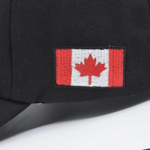 Close-up of high-quality embroidered Canada flag patch on black cotton baseball cap