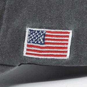 Detailed close-up of American flag embroidery on washed dark grey cotton baseball cap