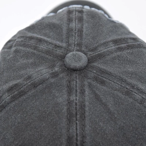 Close-up of washed cotton baseball cap crown with stitched panels and top button