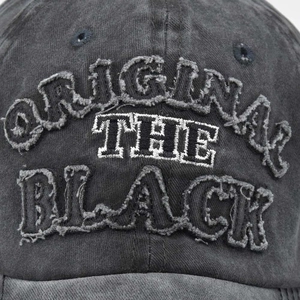 Close-up of 3D embroidery on washed black cotton baseball cap with vintage finish
