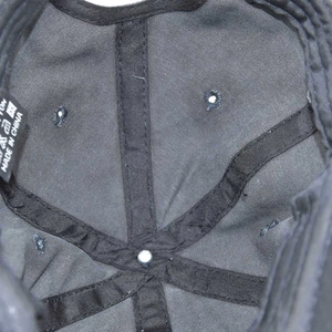 Close-up of black baseball cap interior showing cross reinforcement and wash care label