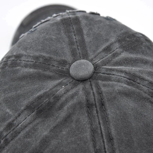 Detail of vintage washed grey baseball cap showing top button and quality stitching