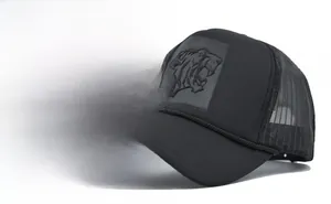 Detailansicht des 3D-geprägten Tiger-Patches auf der schwarzen Mesh-Trucker-Cap mit Kordel