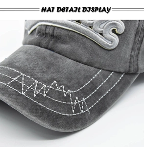 Detail of washed grey baseball cap featuring 3D embroidery and white wavy brim stitching