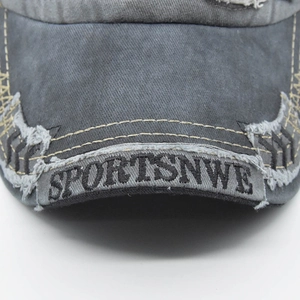 Detailed close-up of vintage washed denim baseball cap with yellow contrast stitching