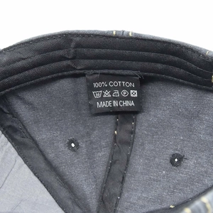 Detailed interior of cotton baseball cap showing stitching and care label with wash icons