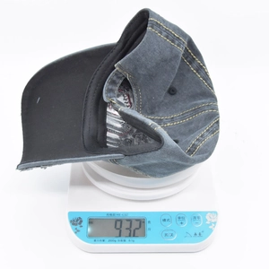 Macro shot of a vintage washed denim baseball cap on a scale weighing exactly 93.2g