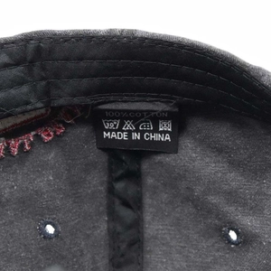 Detailed close-up of 100% cotton material and care label inside a washed baseball cap