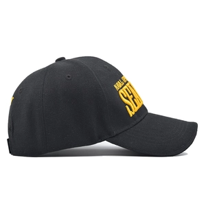 Detail of yellow SEAL TEAM embroidery on a tactical black cotton baseball cap side
