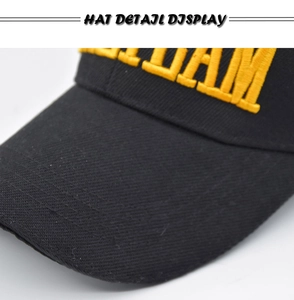 Detailed macro view of yellow 3D embroidery on a black cotton tactical baseball cap