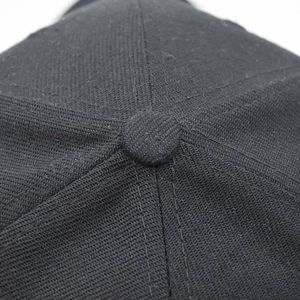 Macro shot of black tactical baseball cap top showing fabric texture and stitching