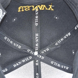 Detail of internal reinforced seams and golden embroidery on black SEAL TEAM tactical cap