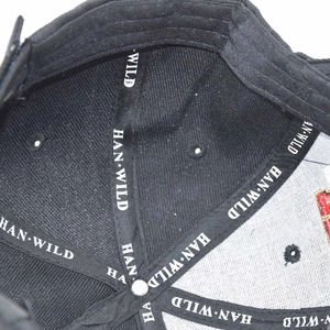 Detailed interior of black USMC tactical cap with branded seam tape and metal button