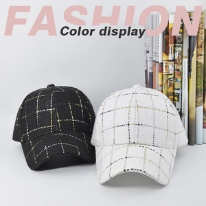 Detail of checkered tweed baseball caps in black and white with subtle metallic threads