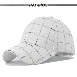 Close-up of white tweed baseball cap with gold and black plaid pattern texture