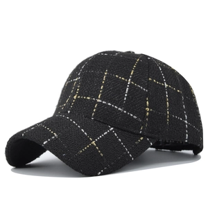 Detail of black plaid baseball cap with gold and silver metallic thread texture
