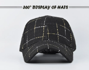 Detailed view of black plaid baseball cap featuring woven gold and silver metallic threads