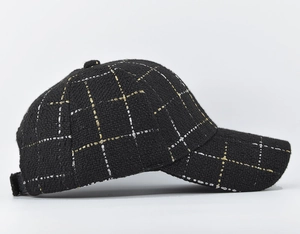 Detailed side view of black plaid tweed baseball cap with gold and silver thread texture