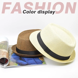 Detail of classic straw fedora hats in brown and cream with black ribbon bands