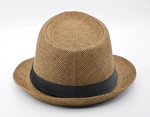 Detail of classic brown straw fedora featuring dense woven texture and black ribbon band
