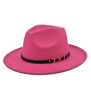 Detail of rose red fedora with wide brim, featuring a black band and gold buckle
