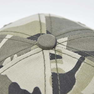 Macro shot of camouflaged cotton baseball cap crown with neat stitching and top button