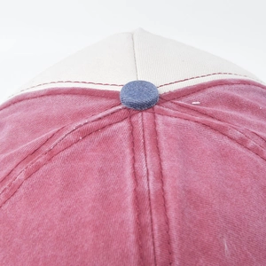 Close-up of washed cotton baseball cap crown with contrast stitching and top button