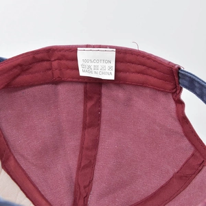 Close-up of baseball cap interior showing red cotton lining and stitched washing label