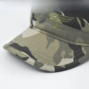 Close-up of camouflage military cap featuring metal army badge and embroidery details